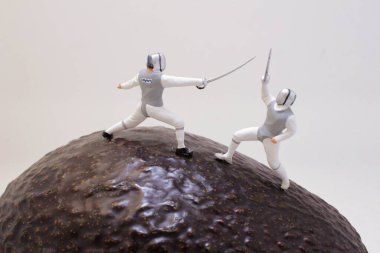 Minyatür figürlerin dokusunda eskrim yaptığı yaratıcı kavramsal sahne