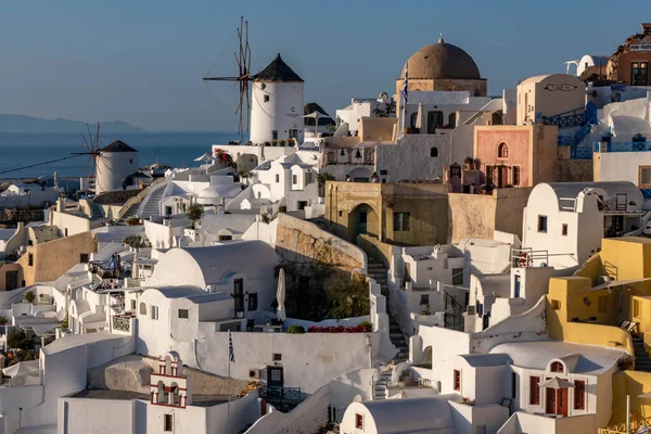 Stock image Colorful buildings and windmill on the hillside at Oia town on Santorini island