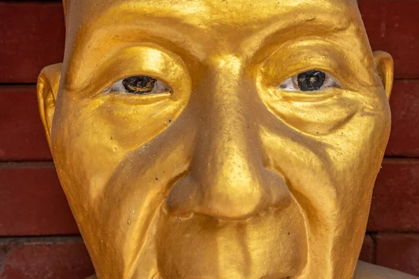 Close-up of a golden Buddha statue's face at a Thailand temple