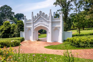 Singapur 'daki Fort Canning Park' ta beyaz kemer yolu ve yeşilliklere giriş.