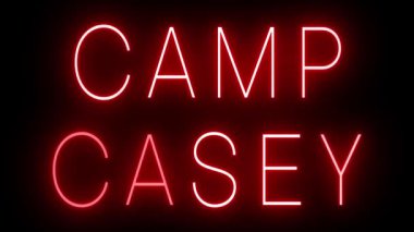 CAMP CASEY için siyah bir arkaplan üzerinde parlayan yanıp sönen kırmızı retro tarzı neon işareti