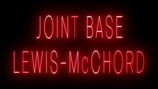 フレッカリングレトロスタイルネオンサイン ジョイントベースLewis Mcchordの黒い背景に輝く — ストック動画
