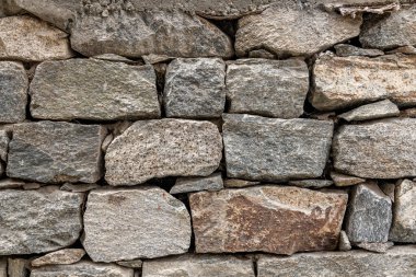 Hindistan 'ın kuzeyindeki Türk köyünde kaya duvar ören taşlardan oluşan karışık boyutlar, şekiller ve renkler.