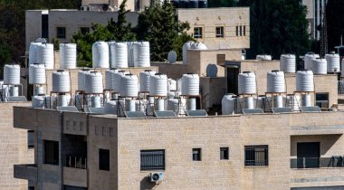 Filistin 'in Ramallah kentindeki bir binanın tepesinde su tankları var.