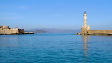 Yunanistan 'da Girit, Chania' daki Ege Denizi 'nin derin mavi sularıyla tarihi deniz fenerinin panoraması ve harabeleri