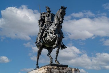 Tiran 'daki halk meydanında parçalı bulutlu gökyüzünün altında savaşçı İskanderbeg' in büyük bronz heykeli