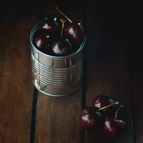 Metal kovada olgun kırmızı kirazlar, kırsal bir arka plan, seçici bir odak