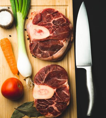 raw fresh beef and vegetables on wood background knife onion tomato osso buco milano italy milanese italian pepper