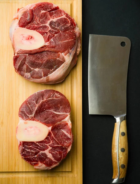 raw beef meat cutting board on black background hatchet