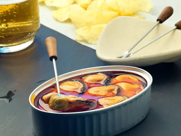 baked potato chips with can seafood,pickled mussels pickled muss and glass of beer