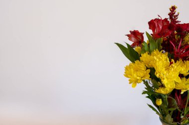 Sarı ve kırmızı çiçeklerden oluşan bir düzenleme sağ tarafta sol tarafta kişisel bir mesaj için odadan çıkıyor...