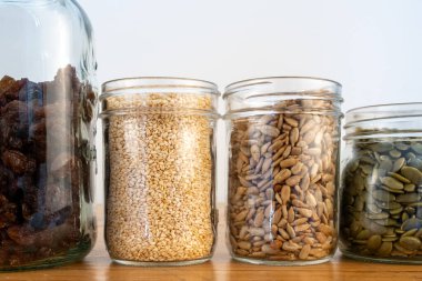 Cam kavanozlardaki tohumlar ahşap mutfak tezgahında..