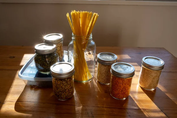 Sürdürülebilir mutfağı temsil eden cam kavanozları ve tohumların dokusunu gösteren ekolojik kileri kapatın.
