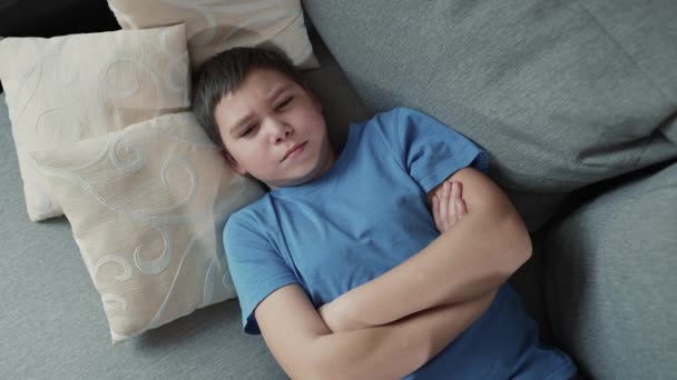 Beleidigter Junge Liegt Mit Gefalteten Händen Auf Der Couch — Stockvideo