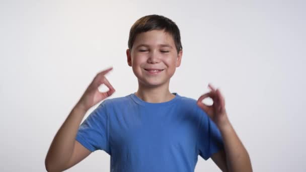 Маленький Кавказский Мальчик Белом Фоне Показывает Знак Пальцами — стоковое видео