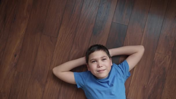 Lächelnder Junge Liegt Auf Dem Boden Und Träumt — Stockvideo