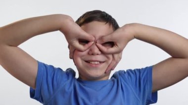 Çocuk süper kahraman maskesi gibi parmaklarını yaptı ve ona baktı.