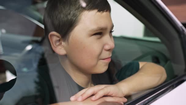 Uśmiechnięty Chłopiec Patrzy Przez Okno Samochodu — Wideo stockowe