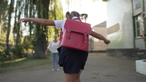 楽しい娘は学校の後に母親に走って抱きしめます — ストック動画