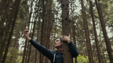 Yürüyüşte cep telefonu bağlantısı arayan bir turist, telefonunu kaldırdı.