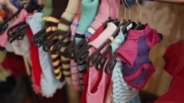 Kediler ve köpekler için elbiseler mağazadaki trempellere asılı.