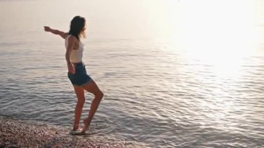 Kaygısız kız su sıçratma oyunu oynuyor sahilde eğleniyor