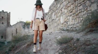 Bir kadın arkeolog, ortaçağ şatosunun yıkıntıları etrafında gezinerek tarihini ve yapısını araştırıyor..