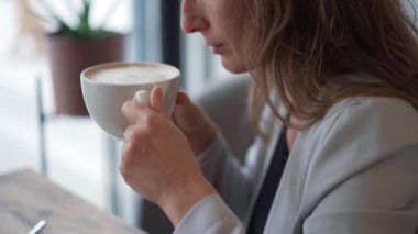 Öğleden sonra sıcacık bir kafede sıcak bir fincan kahvenin tadını çıkarıyorum.