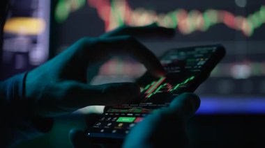 Gerçek zamanlı ticareti, dengesizliği ve dijital finans anlaşmasını sembolize eden canlı bir kripto grafiği olan akıllı telefonu yakın plan çekimleri.