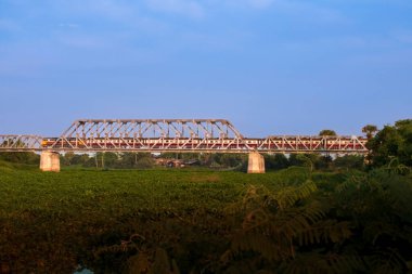 Dizel lokomotifle yolcu treni demiryolu köprüsünden geçti.