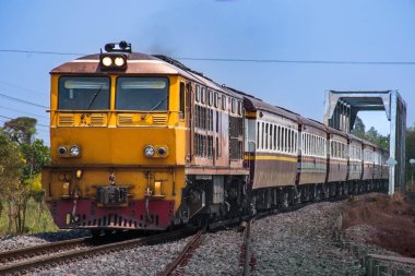 Dizel lokomotifle yolcu treni demiryolu köprüsünden geçti.