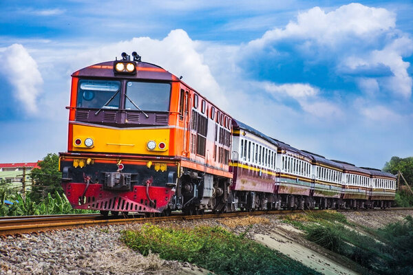 Passenger train by diesel locomotive on the railway curve.