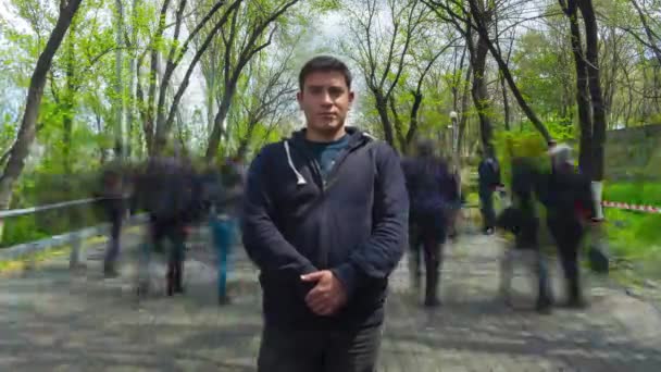 Hombre Solitario Está Inmóvil Sobre Fondo Gente Borrosa Caminando Árboles — Vídeo de stock
