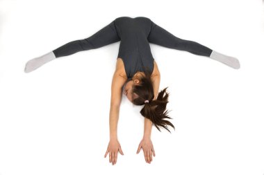 Genç ve güzel bir kadın, beyaz arka planda esneme egzersizi yapıyor. Stüdyo çekimi.