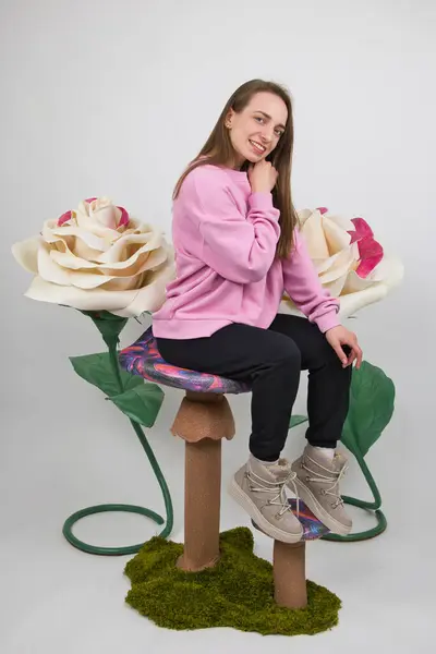 Bir Kız Büyük Yapay Beyaz Güllerin Arka Planında Gülümseyerek Poz Stok Fotoğraf
