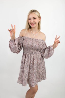 Güzel, geniş gülüşlü, el işaretleri yapan neşeli dansçı. Işık arkaplanına yakın plan