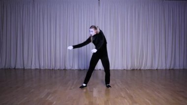 Pandomim sahnesi: İki uzun at kuyruklu sarışın pandomim kızı hayali bir halat çekiyor, ışık saçan renklerin olduğu bir sahne..