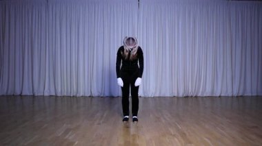 Pandomim sahnesi, iki uzun at kuyruklu sarışın pandomim kızı, bir kukla bebek, bir robot, parlak renkli bir sahne.