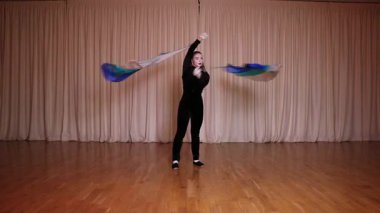 Pandomim sahnesi, iki uzun at kuyruklu sarışın pandomim kızı, poi 'nin uzun kumaşla çalıştığını gösteriyor, parlak renkli sahneler..