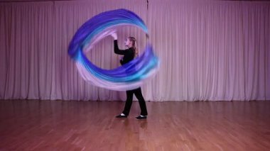 Pandomim sahnesi, sahnede poi numarası yapan bir aktris, uzun bir bez parçasıyla dairesel bir rotasyon. Sahne çok renkli yanardöner ışıklarla aydınlatılıyor..