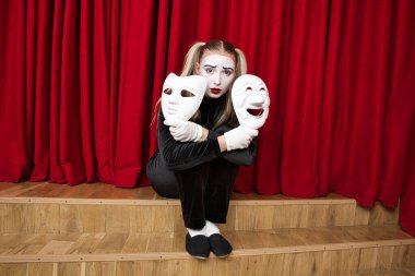 Odak noktası elinde maske olan bir pandomimci. Yakın plan portre.