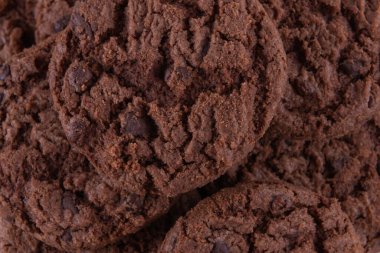 Tasty chocolate chip cookies on white plate on wooden background. Selective focus.