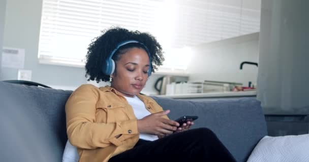 Wanita Muda Bersantai Sofa Nyaman Dengan Mata Tertutup Mengenakan Headphone — Stok Video