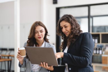 Çeşitli iş adamları birlikte çalışarak şirket mali istatistiklerini tartışıyor, çok ırklı meslektaşlar tabletteki finansman ile beyin fırtınası yapıyor