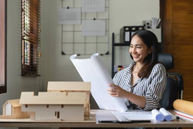 Ofiste taslak üzerinde çalışan Asyalı kadın mimar.