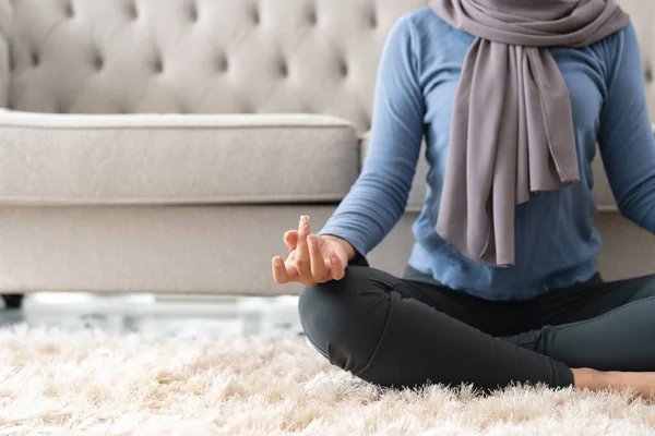 Stress management concept. Close up peaceful young lady in hijab meditating at home.