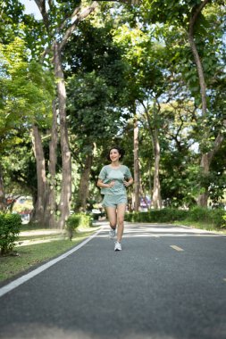 Asyalı kadın koşucular. Sabahleyin parkta koşuyordu.