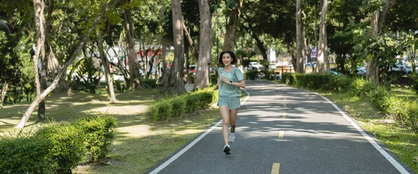 亚洲女赛跑选手她早上在公园里跑步 — 图库照片