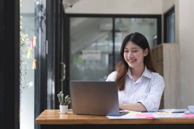 Muhasebe muhasebe için dizüstü bilgisayarda çalışan çekici Asyalı kadın.