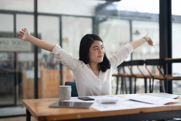 Young Asian Business Accountant woman stretching herself and relax while working hard